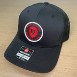 Gorra trucker negra con parche redondo y etiqueta roja